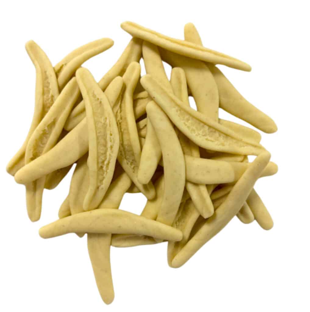Close-up of handcrafted Fogliette de Ulivo pasta, shaped like olive leaves and lightly dusted with semolina